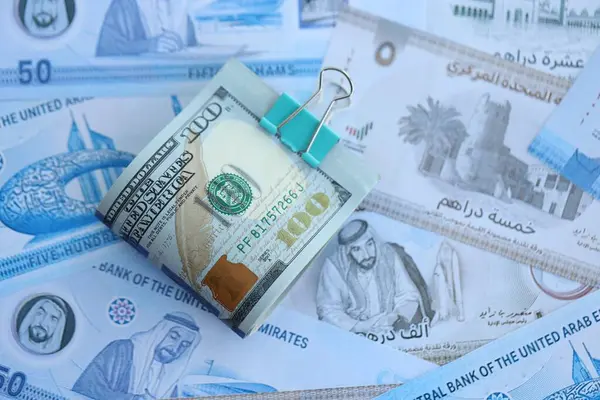 Birleşik Arap Emirlikleri kara para birimi faturaları ve biz dolar banknotları yakın yakın. Ekonomi ve döviz kuru kavramı