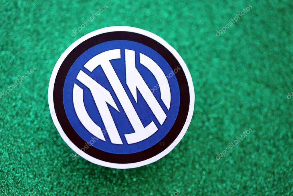 KYIV, UKRAINE - FEBRUARY 23, 2025 Inter Milan FC football club badge lies on emerald green glitter background banner