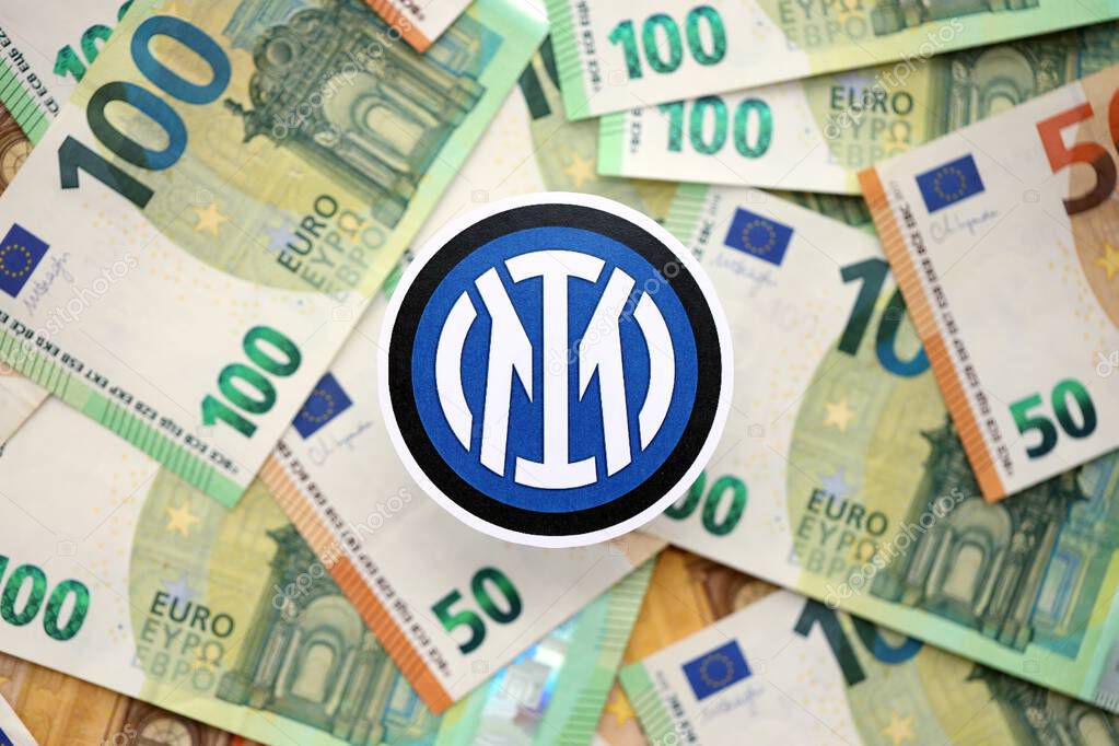 KYIV, UKRAINE - FEBRUARY 23, 2025 Inter Milan FC football club badge lies on big amount of hundred EURO money bills