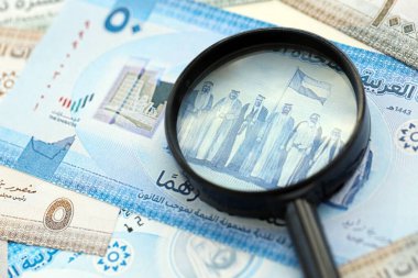 Birleşik Arap Emirlikleri kara para birimi banknotları ve büyüteç yakın çekim. Finansal izleme ve vergilendirme kavramı