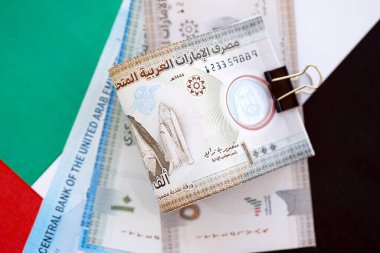 Birleşik Arap Emirlikleri kara para birimi banknotları bayrağa yakın duruyor. İş ve yatırım kavramı