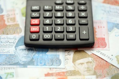 Pakistan banknotları ve hesap makinesi. Pakistan 'ın mevcut para ve hesap makinesi büyük miktarda masada yatıyor. Pakistan 'da vergi ve para sayımı kavramı