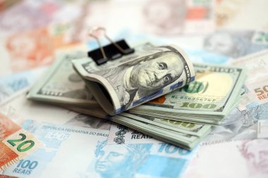 Bir sürü Amerikan doları büyük miktarda Brezilya banknotunun üzerinde yatar. Amerika 'nın parası Brezilya' nın para akışına bağlı. Brezilya 'da ekonomi ve döviz kuru kavramı