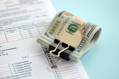 Masada 1040 bireysel gelir vergisi iadesi formuyla birlikte büyük miktarda Amerikan doları banknotları var. ABD 'de vergilendirme ve muhasebe kavramı