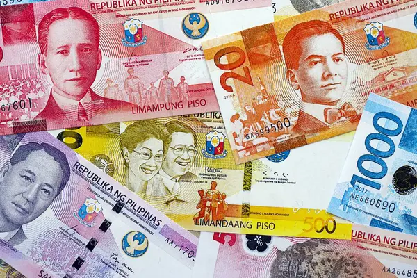 Filipinler Peso para birimi faturaları. Mevcut banknotlar masanın üzerinde büyük miktarda yatıyor.