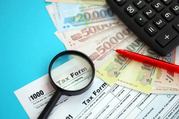 Vietnam çadırı para faturaları ve mavi üzerine yakın vergi formlu hesap makinesi. Vergi ve muhasebe kavramı