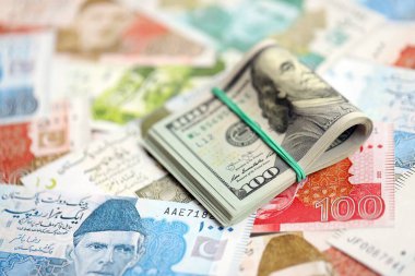 Bir sürü Amerikan doları Pakistan Rupileri 'nin banknotlarına yakın duruyor. Amerikan para demeti Pakistan 'ın para banknotlarında yatıyor. Pakistan 'da ekonomi ve döviz kuru kavramı