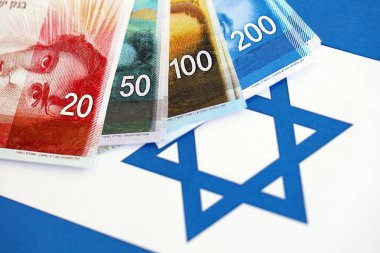 Israel New Shekels banknotları ulusal bayrak üzerinde. İsrail 'in şu anki para faturaları büyük oranda bayrağın üzerinde yatıyor. İsrail 'de iş ve yatırım kavramı