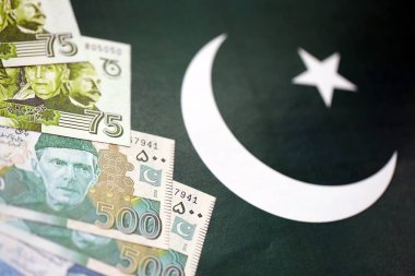 Pakistan 'ın bayrak geçmişi üzerine Pakistan banknotları. Pakistan 'ın mevcut para faturaları büyük miktarlarda pankartta yatıyor. Pakistan 'da ekonomi ve ticaret kavramı