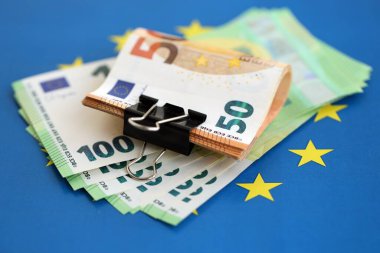 Avrupa sendikasının mavi bayrağına bir deste avroluk banknot yakın. Avrupa 'da iş ve ekonomi kavramı