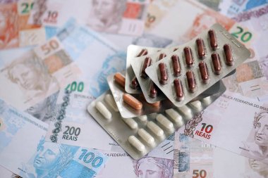 Brezilya bankaları ve ilaç hapları. Mevcut Brezilya gerçek para ve uyuşturucu banknotları büyük miktarda masada yatıyor. Brezilya 'da ilaç ve eczane kavramı