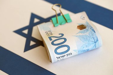 Israel New Shekels banknotları ulusal bayrak üzerinde. İsrail 'in şu anki para faturaları büyük oranda bayrağın üzerinde yatıyor. İsrail 'de iş ve yatırım kavramı