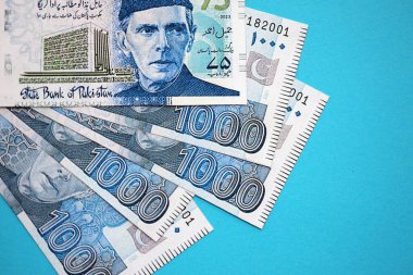 Pakistan banknotları mavi arka planda. Pakistan 'ın mevcut para faturaları büyük miktarda masada yatıyor. Pakistan 'da iş ve yatırım kavramı