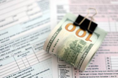 Masada 1040 bireysel vergi iadesi formuyla birlikte büyük miktarda Amerikan doları var. ABD 'de vergilendirme ve muhasebe kavramı