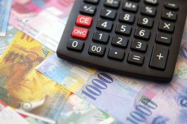 İsviçre frangı banknotları ve hesap makinesi. Mevcut frank para faturaları ve calc büyük miktarda masada yatıyor. İsviçre 'de vergilendirme ve para konsepti