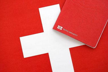 Bayrağın üstünde İsviçre pasaportu. Şimdiki İsviçre bayrağı yakından geçiyor. İsviçre 'de vatandaşlık kavramı