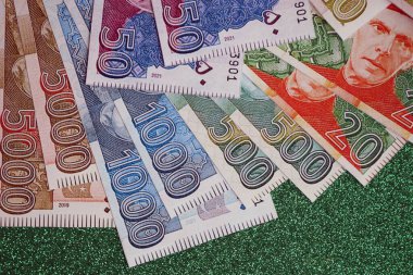 Pakistan parlayan yeşil arka planda banknotlar halinde. Pakistan 'ın mevcut para faturaları büyük miktarda masada yatıyor. Pakistan 'da iş ve yatırım kavramı