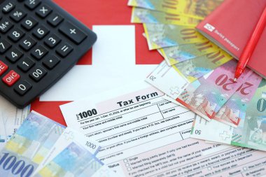 İsviçre frangı banknotları ve vergi formları. Mevcut para faturaları vergi formu ve bayraklarda yatıyor. İsviçre 'de vergilendirme kavramı