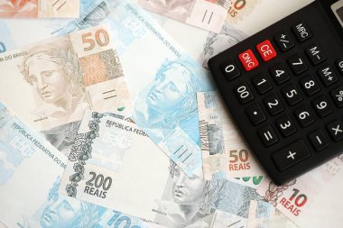 Brezilya banknotları ve hesap makinesi. Mevcut Brezilya gerçek para ve hesap makinesi büyük miktarda masada yatıyor. Brezilya 'da vergilendirme ve para konsepti