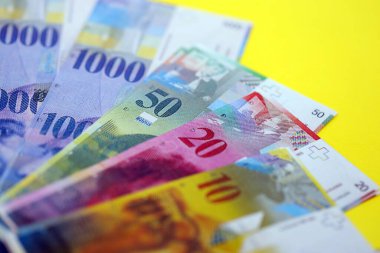 Sarıya İsviçre frangı banknotları. Mevcut frank para faturaları büyük miktarda masada yatıyor. İsviçre 'de iş ve yatırım kavramı