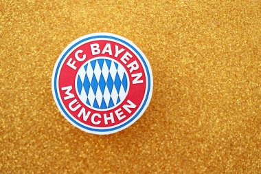 KYIV, UKRAINE - 23 Şubat 2025 Bayern Münih futbol kulübü rozeti altın sarısı parıltılı arka plan pankartıyla uzanır