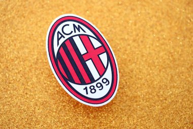 KYIV, UKRAINE - 23 Şubat 2025 AC Milan futbol kulübü rozeti altın sarısı parıltılı arka plan pankartıyla uzanır