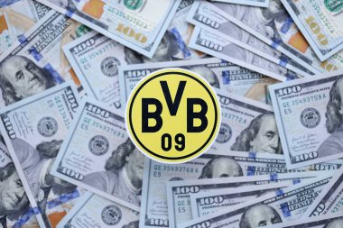 KYIV, UKRAINE - 23 Şubat 2025 Borussia Dortmund futbol kulübü rozeti yüzlük banknotların üzerinde yatıyor