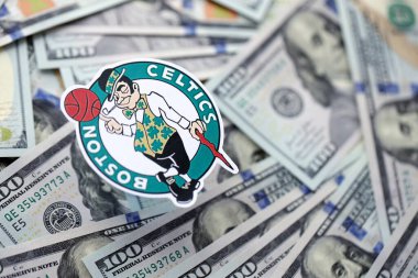 KYIV, UKRAINE - 23 Şubat 2025 Boston Celtics basketbol takımı rozeti yüzlük banknotların üzerinde.