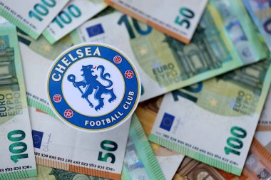 KYIV, UKRAINE - 23 Şubat 2025 Chelsea FC futbol kulübü rozeti büyük miktarda EURO para banknotlarının üzerinde yatıyor
