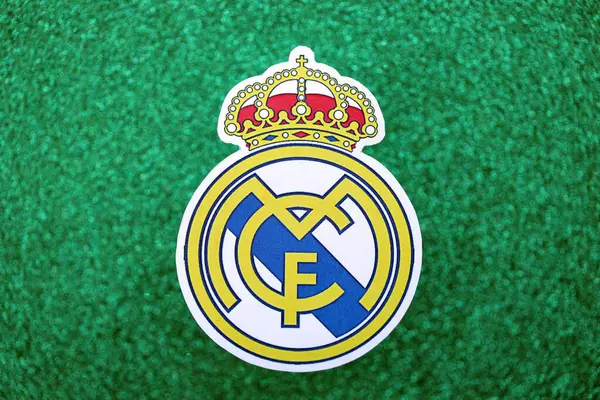 KYIV, UKRAINE - 23 Şubat 2025 Real Madrid CF futbol kulübü rozeti zümrüt yeşili simli arka plan pankartıyla uzanır