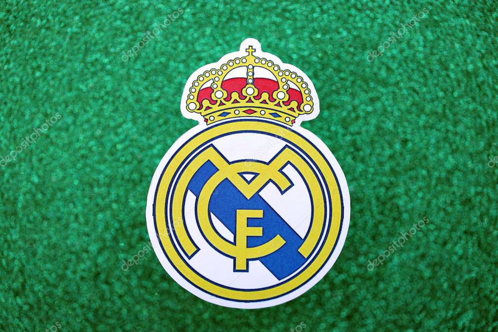 KYIV, UKRAINE - FEBRUARY 23, 2025 Real Madrid CF football club badge lies on emerald green glitter background banner
