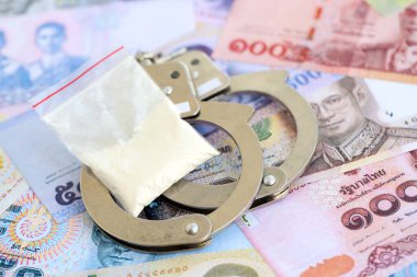 Tayland baht para birimi faturaları ve kelepçeli kokain paketi. Uyuşturucu suçları kavramı