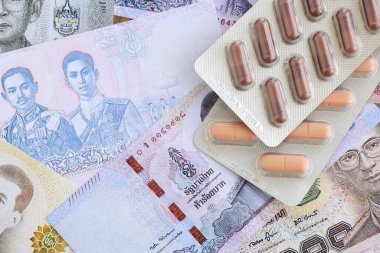 Tayland baht para birimi faturaları ve ilaç hapları. İlaç ve eczane kavramı
