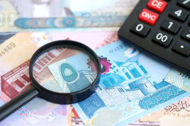 Bahreyn dinar para birimi faturaları ve yakınlaştırıcı bardaklı hesap makinesi. Vergilendirme ve para sayımı kavramı