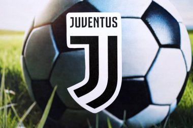 KYIV, UKRAINE - 23 Şubat 2025 Juventus FC futbol kulübü rozeti futbol topu arka planında yer alıyor