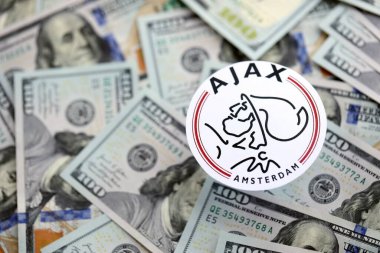 KYIV, UKRAINE - 23 Şubat 2025 AFC Ajax futbol kulübü rozeti büyük miktarlarda Amerikan doları üzerinde yatıyor