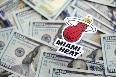KYIV, UKRAINE - 23 Şubat 2025 Miami Heat basketbol takımı rozeti yüzlük banknotların üzerinde.
