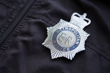 KYIV, UKRAINE - 17 Eylül 2025 İngiltere Büyükşehir Polis Teşkilatı rozeti siyah üniformalı kumaş yüzeyi