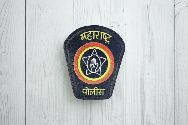 KYIV, UKRAINE - SEPTEMBER 17, 2025 India Police badge on white wooden table surface close up