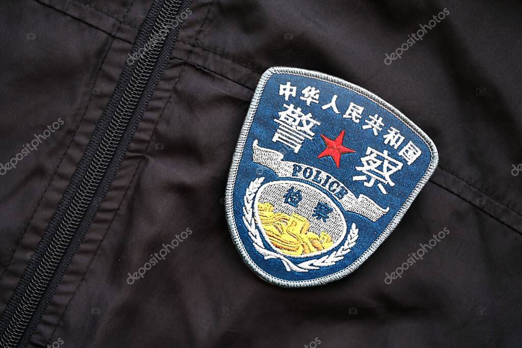 KYIV, UKRAINE - SEPTEMBER 17, 2025 Chinese Police badge on black uniform fabric surface close up