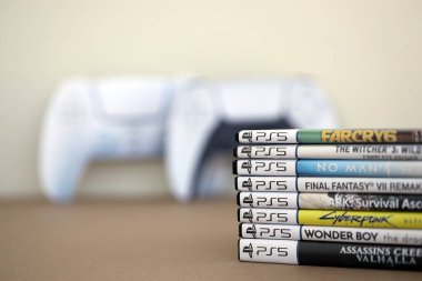 KYIV, UKRAINE - 17 Eylül 2025 PS5 video oyun disk kutuları ve modern dualsense kenar oyun sahası yakınlaşması