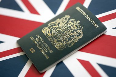 KYIV, UKRAINE - 17 Eylül 2025 İngiliz bayrağında yeni siyah İngiliz pasaportu