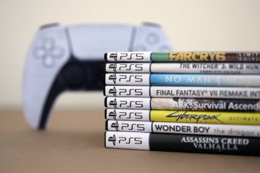 KYIV, UKRAINE - 17 Eylül 2025 PS5 video oyun disk kutuları ve modern dualsense kenar oyun sahası yakınlaşması