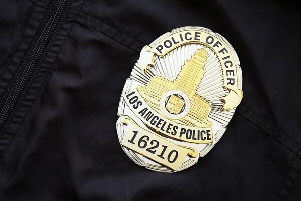 KYIV, UKRAINE - SEPTEMBER 17, 2025 US LAPD Police officer badge on black uniform fabric surface close up