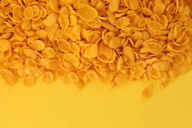 Kahvaltı gevreklerinin arka planında büyük miktarda sarı arka planda yakın plan, üst manzara