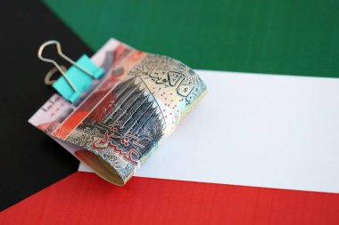 Kuveyt dinarı para birimi banknotları bayrağa yakın duruyor. İş ve yatırım kavramı