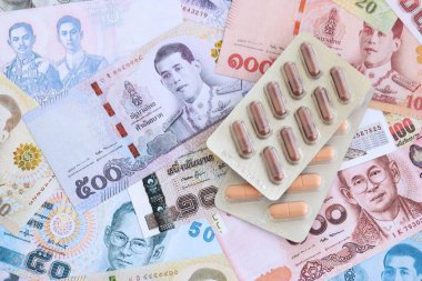 Tayland baht para birimi faturaları ve ilaç hapları. İlaç ve eczane kavramı
