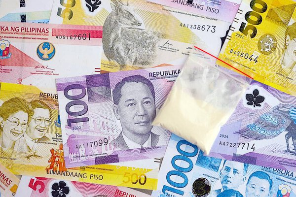 Philippines peso currency money bills and cocaine pack close up. The concept of drug trafficking