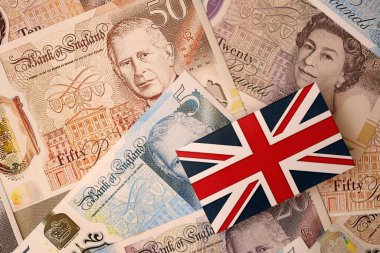 KYIV, UKRAINE - 17 Eylül 2025 Büyük miktarda İngiliz sterlini ve İngiliz bayrağı