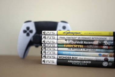 KYIV, UKRAINE - 17 Eylül 2025 PS5 video oyun disk kutuları ve modern dualsense kenar oyun sahası yakınlaşması